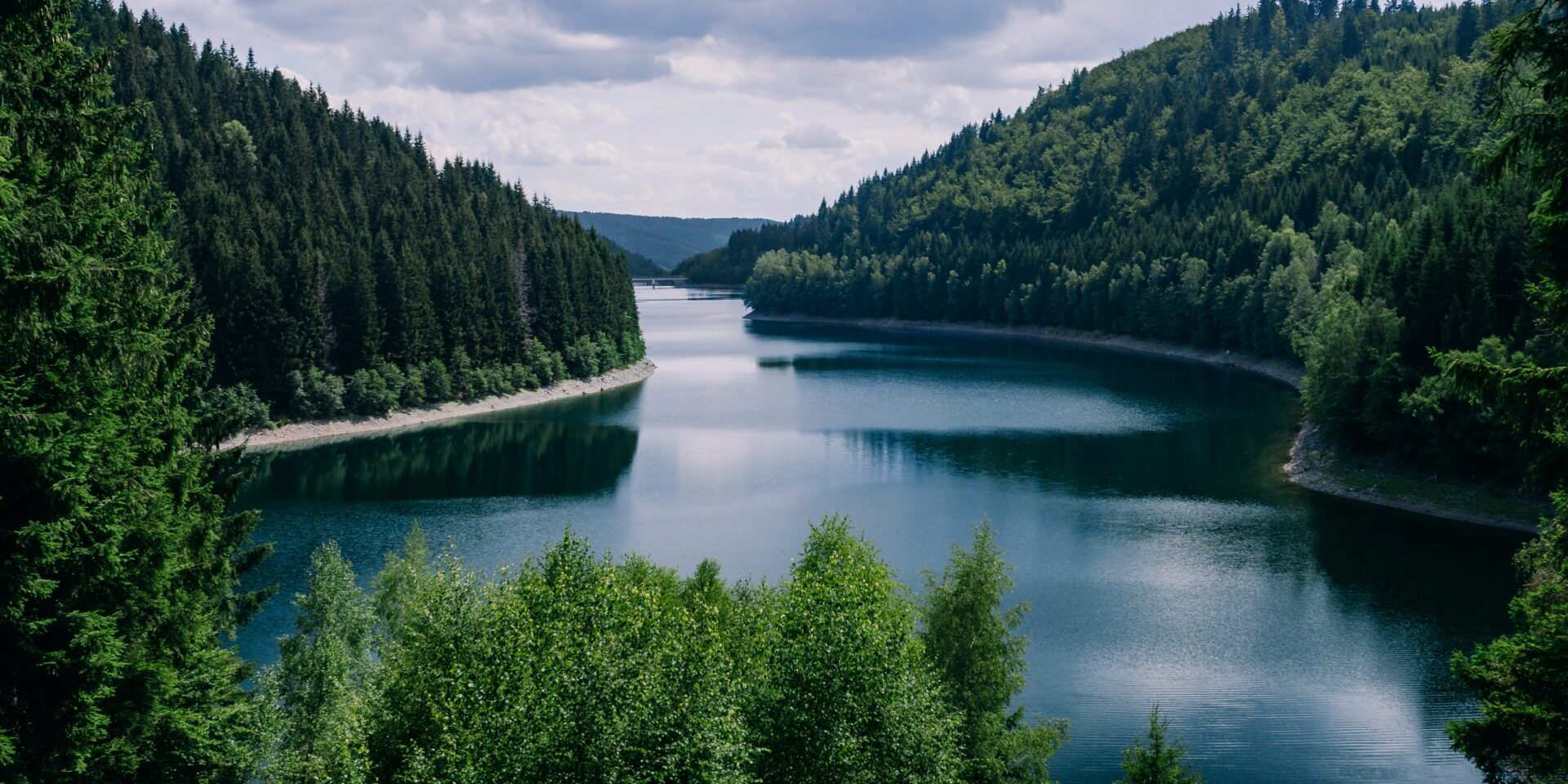 A river surrounded by forests under a cloudy sky in Thuringia in Germany - great for natural concepts